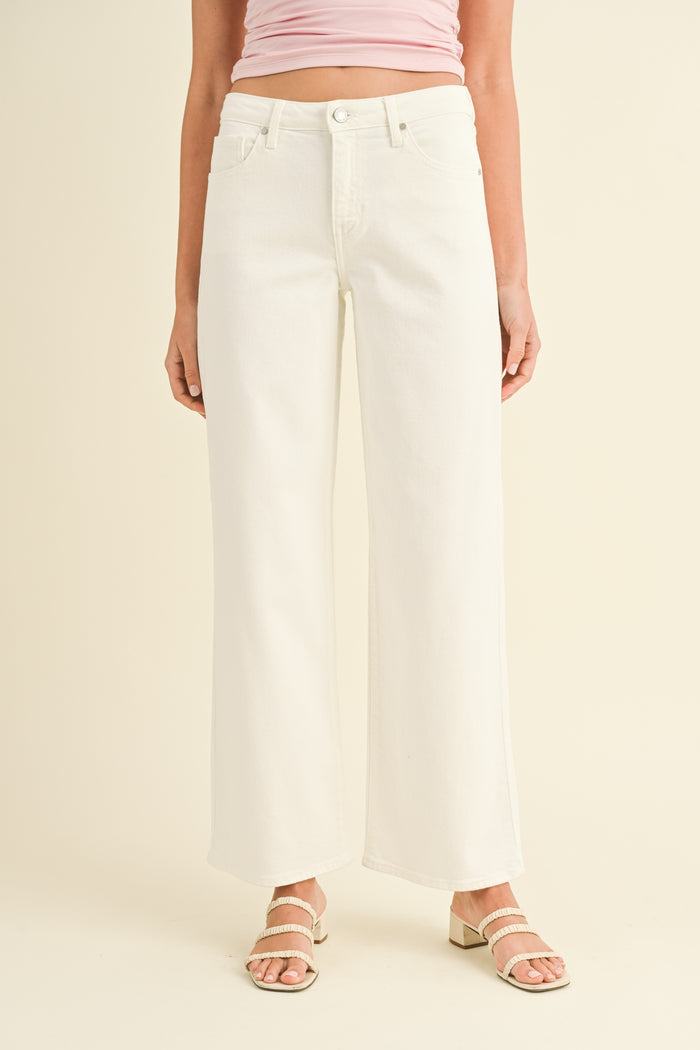 White wide-leg jeans with high waist, button closure, and full-length straight silhouette.
