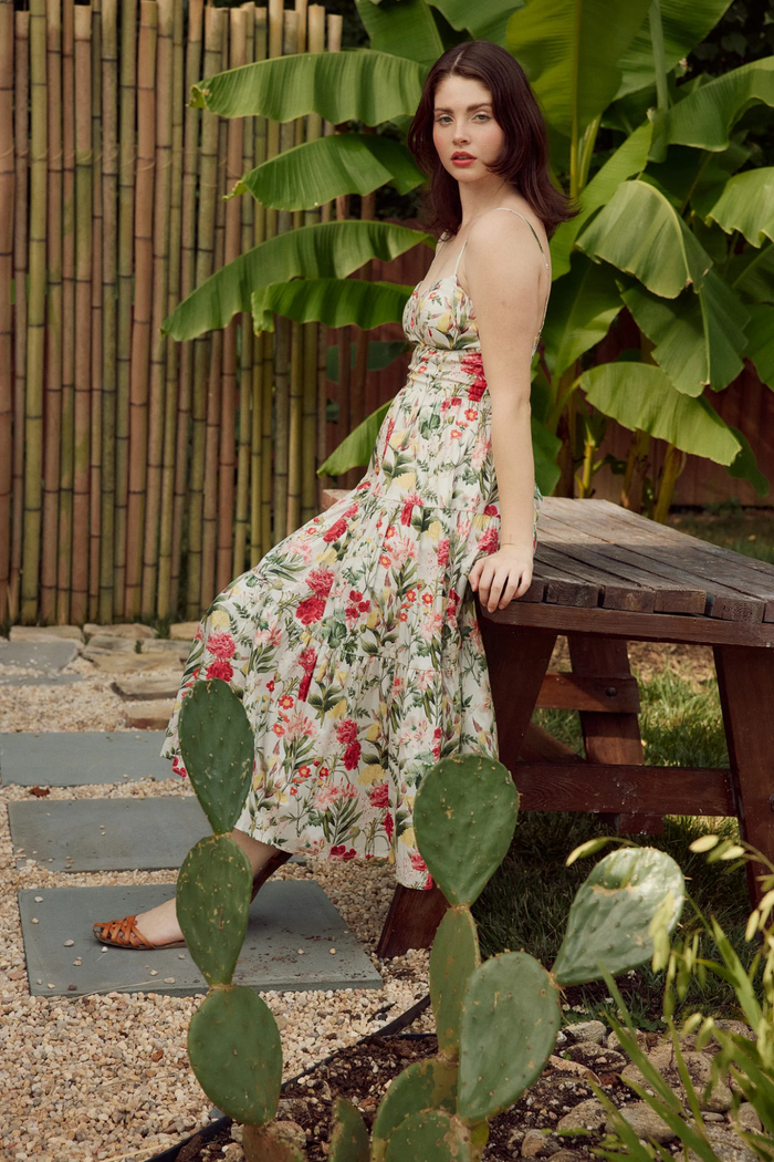 Sleeveless maxi dress with red and pink floral print on cream background, halter neckline, fitted waist.