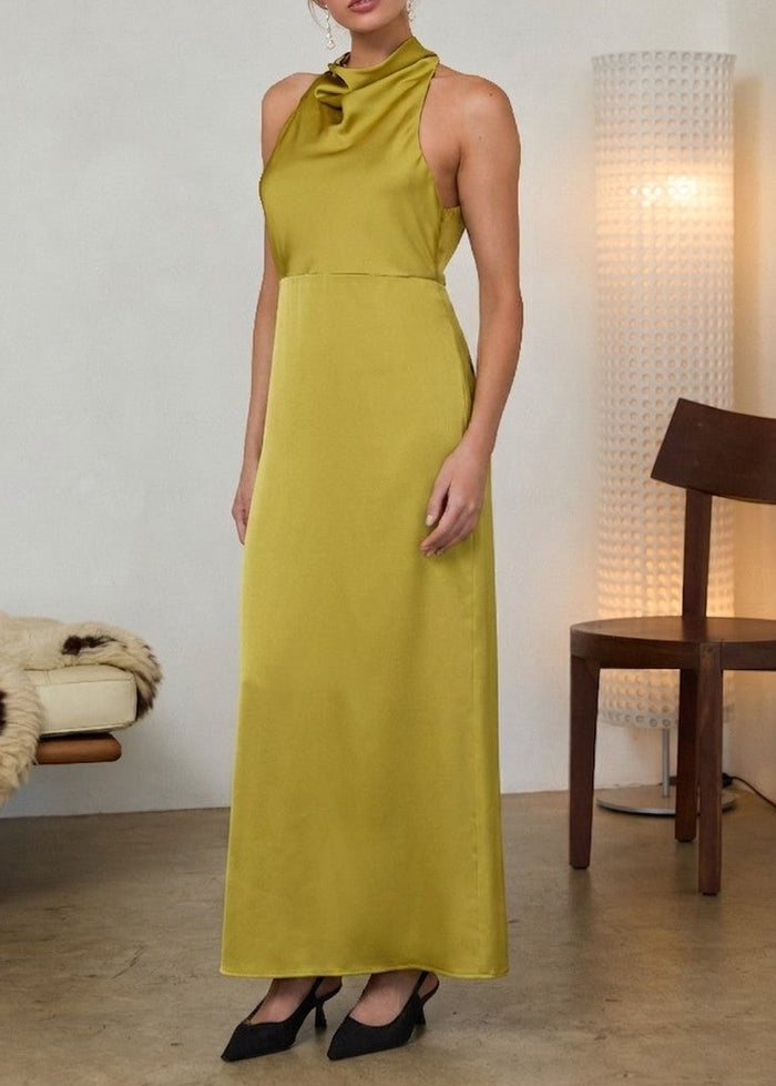 Chartreuse halter maxi dress with draped neckline and sleeveless cut, styled with black pointed-toe heels.