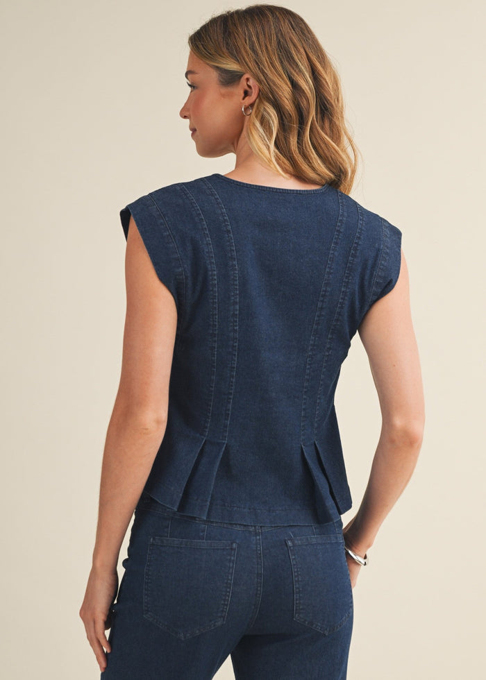 Woman wearing a blue denim outfit with a plain background