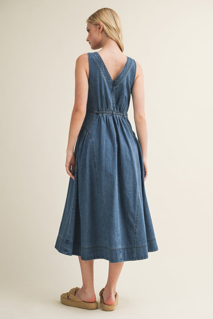 Blue denim midi dress with V-neckline, sleeveless design, and gathered waist detail, shown from back view.