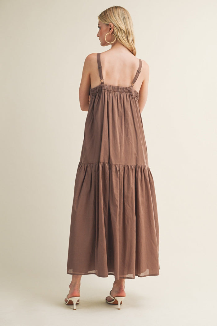 Brown sleeveless maxi dress with tiered layers and adjustable straps, shown from back view on model.