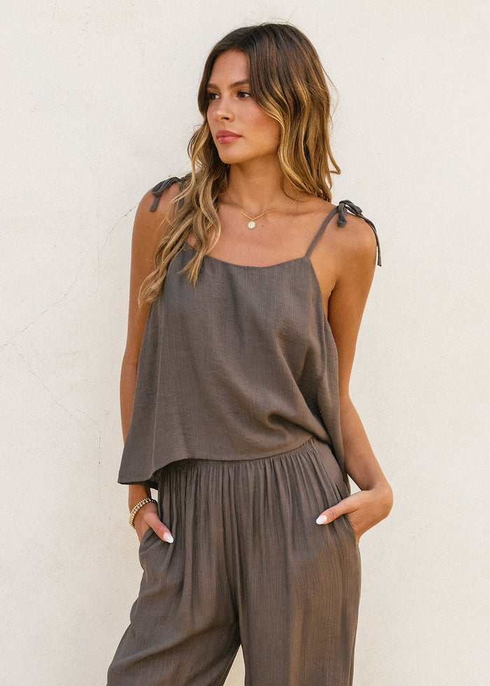 Gray boxy cami top with tie shoulder straps and matching pleated pants, shown on a model against a neutral background.