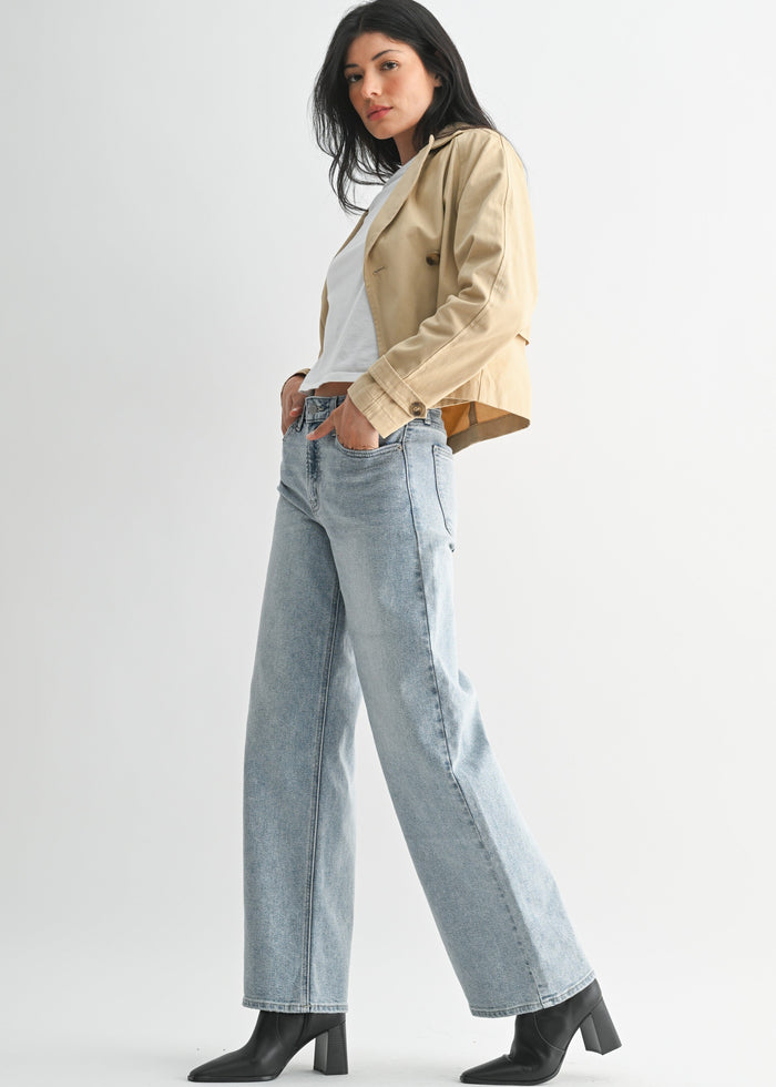 Light-wash high-rise straight jeans with a five-pocket design, paired with a white tank and beige jacket.