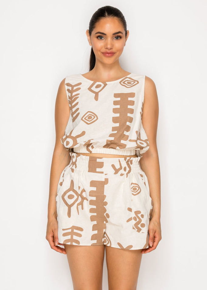 Cream sleeveless seersucker top with tan geometric pattern and matching shorts, worn by model against white background.