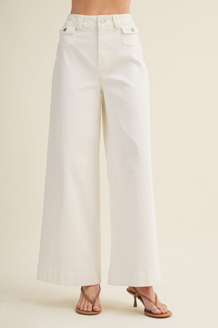 White wide-leg jeans worn by a person on a beige background