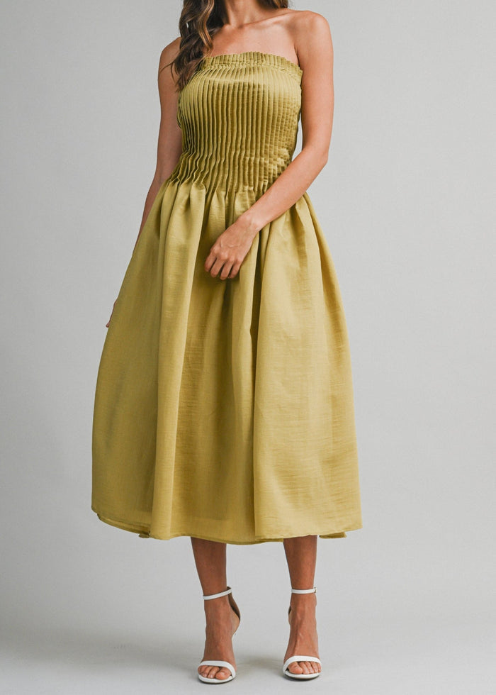 Chartreuse strapless midi dress with pleated bodice and full skirt, worn with white strappy sandals.