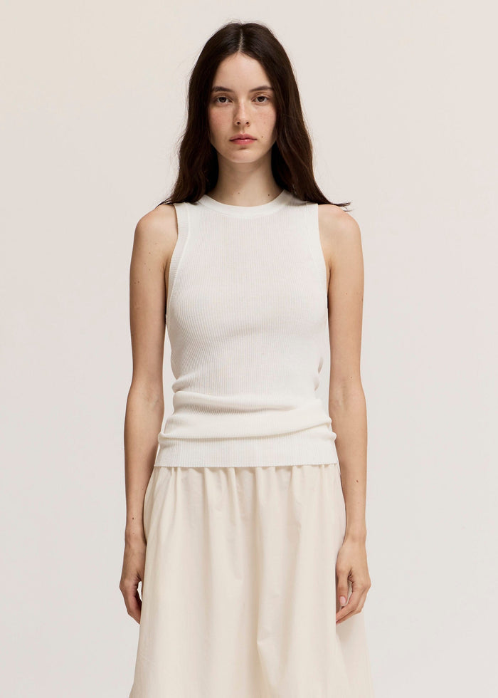 Cream ribbed knit sleeveless tank top with crew neckline worn with matching skirt.