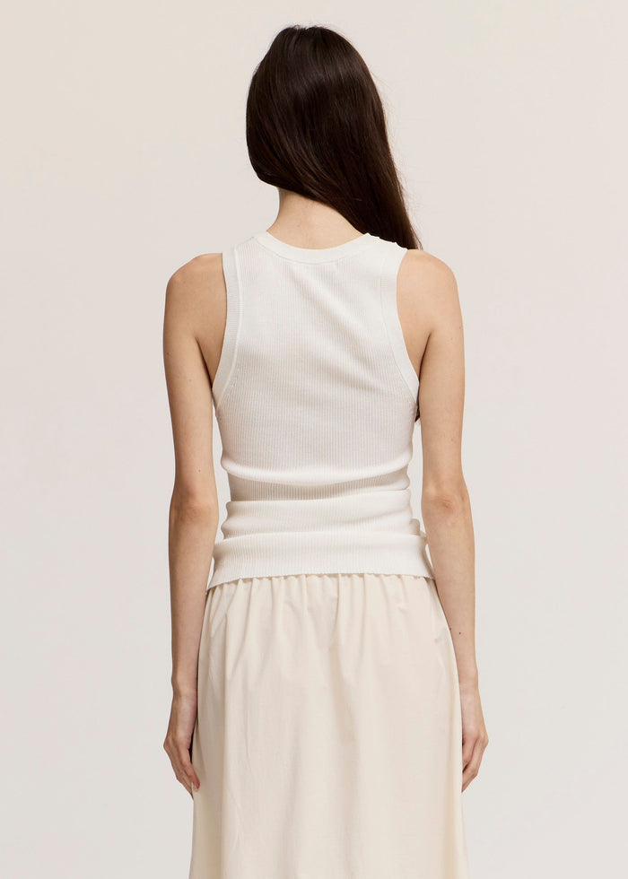 Cream ribbed knit tank top with crew neckline and sleeveless design, shown on model from back view.