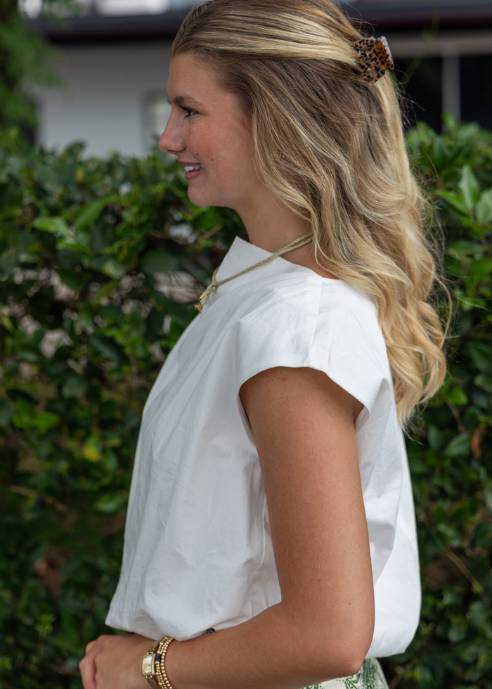 White short-sleeve top with gathered bubble hem and tie-back neckline detail.