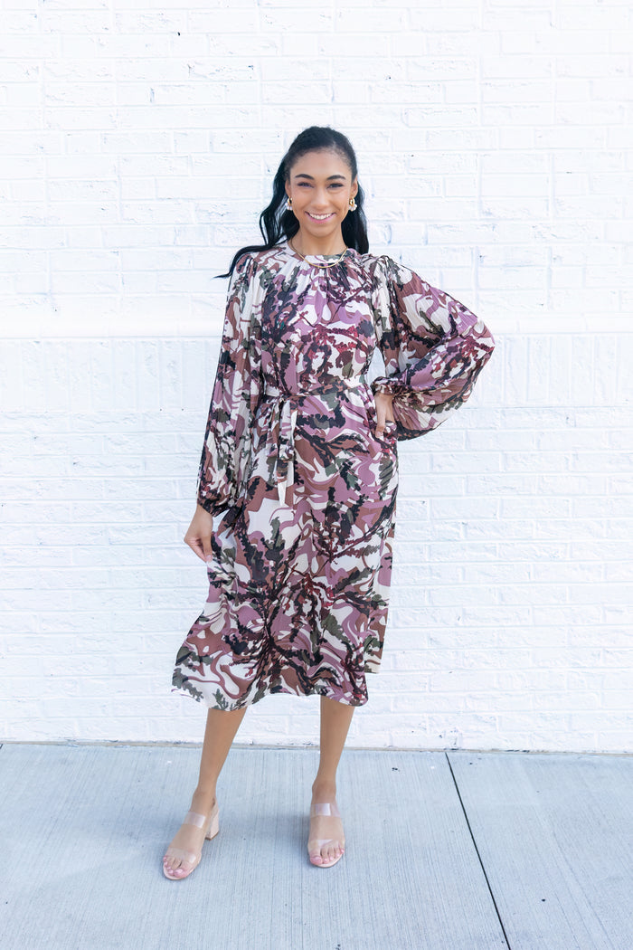 Midi dress with burgundy and black abstract floral print, long puffed sleeves, and tie waist detail.