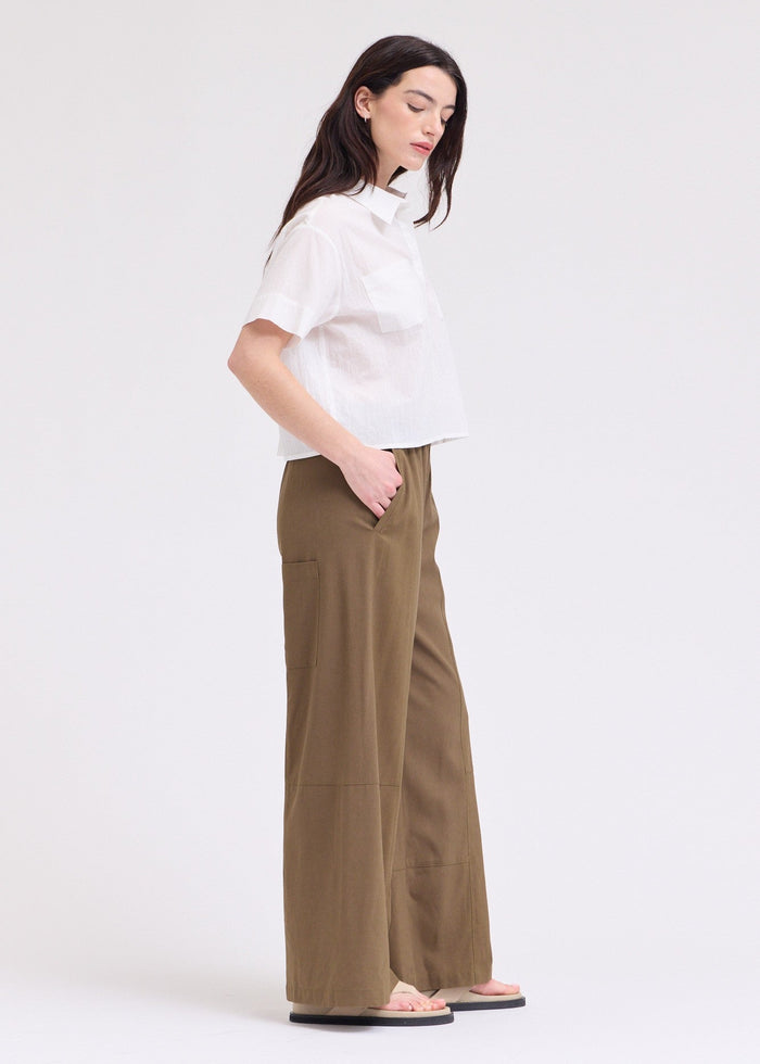 White button-up top with short sleeves and collar, worn with olive cargo pants.