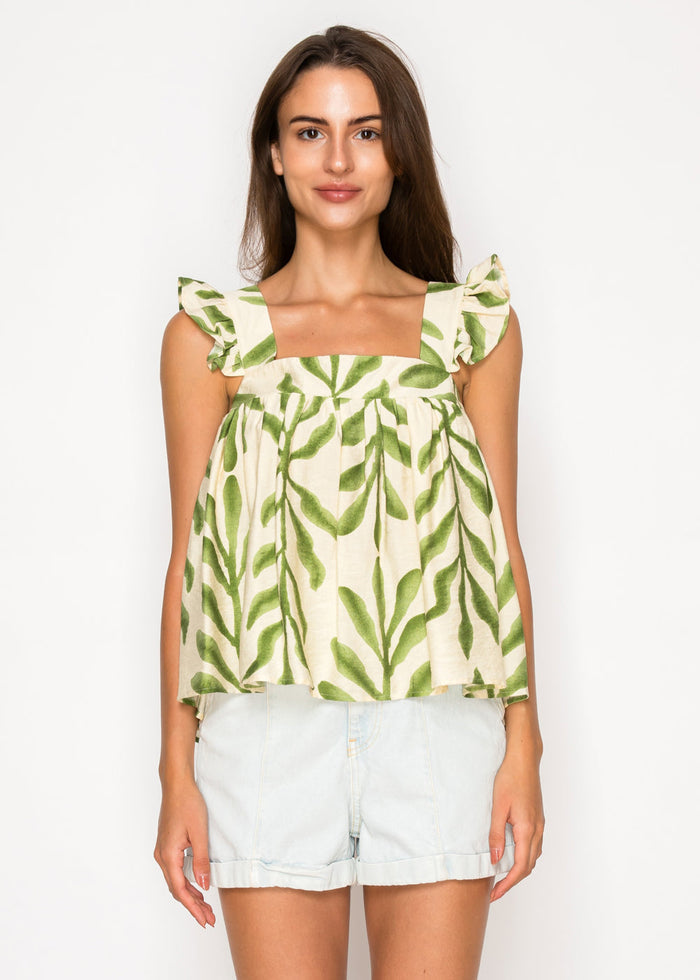 Cream and green leaf-print top with ruffled cap sleeves and square neckline, paired with white denim shorts.