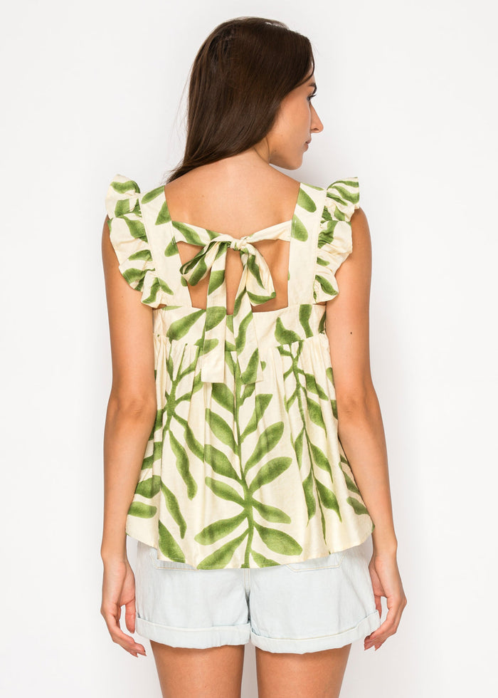 Cream sleeveless top with green leaf print and ruffled back straps tied in a bow cutout.