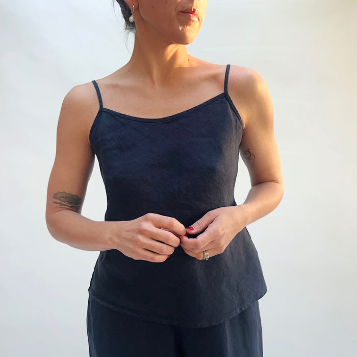 Person wearing a black tank top against a white background