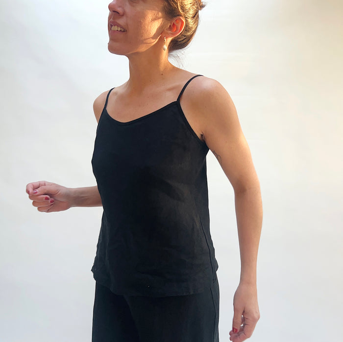 Person wearing a black tank top against a white background