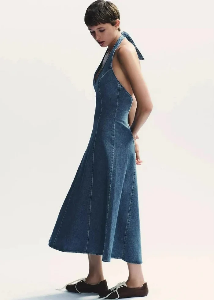 Blue denim sleeveless maxi dress with V-neckline and A-line silhouette on model.