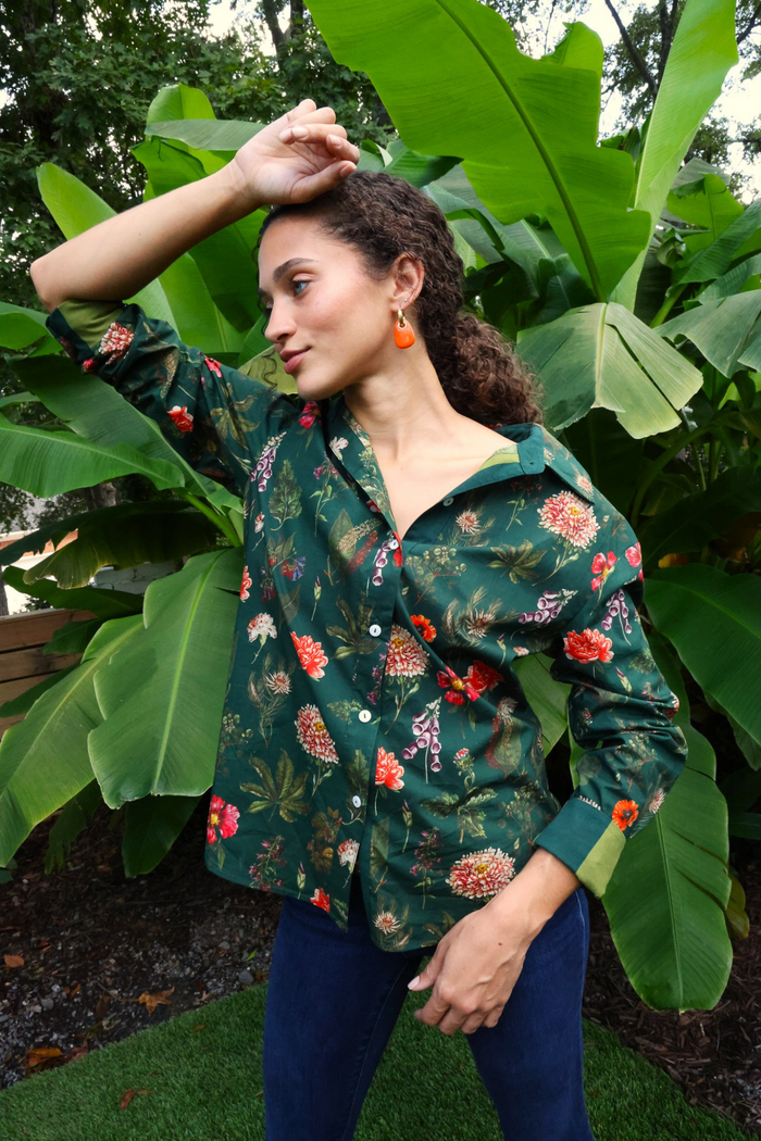 Dark teal button-down shirt with red and pink floral print, worn with navy pants.