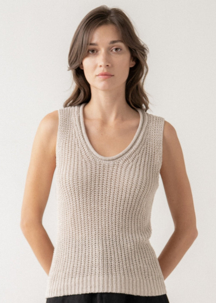 Beige sleeveless knit top with ribbed texture and crew neckline on model against neutral background.