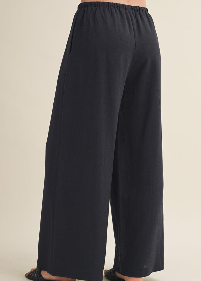 Black wide-leg pants with elastic waistband shown from back view.