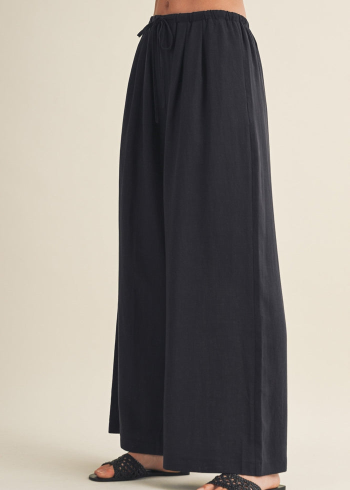 Black wide-leg pants with drawstring waist and full-length silhouette.