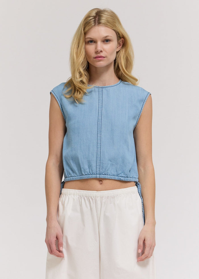 Light blue chambray sleeveless crop top with center seam and elastic waistband.