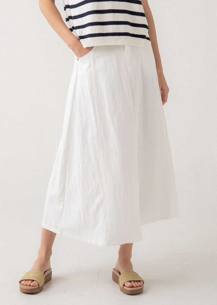 White linen a-line midi skirt with side pockets and inverted pleats at waist.
