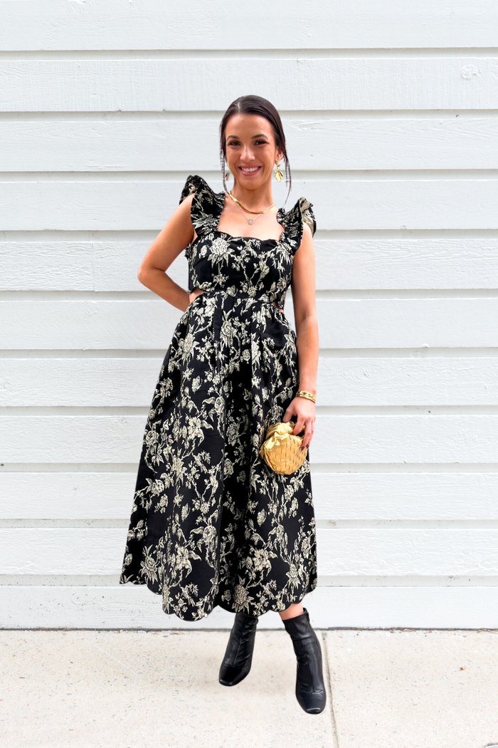 Black midi dress with cream floral print, ruffled cap sleeves, and fitted bodice.