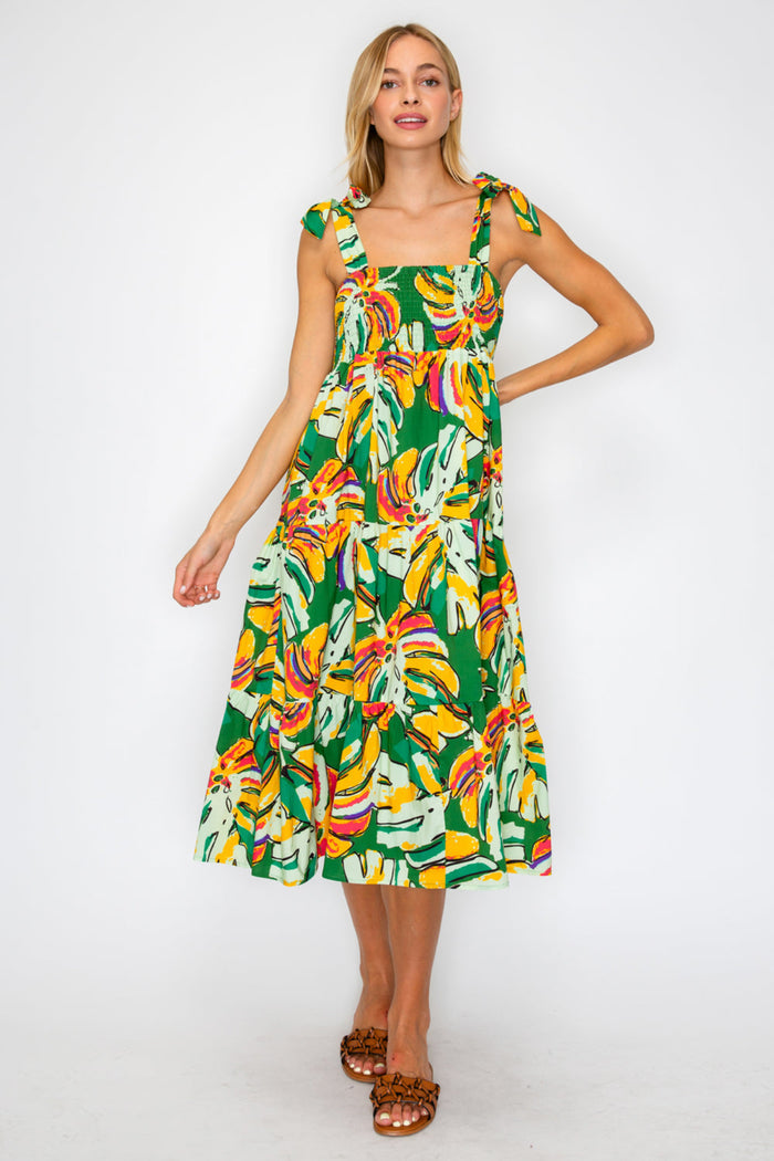 Woman wearing a colorful dress with a banana leaf pattern on a white background