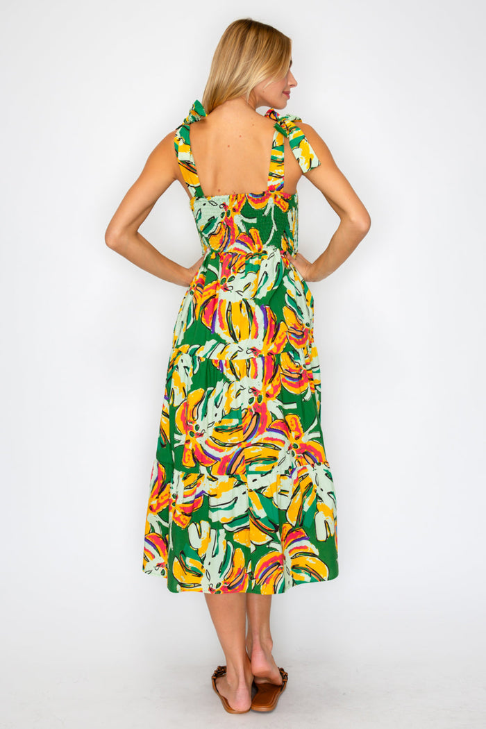 Woman wearing a colorful dress with a banana leaf pattern on a white background