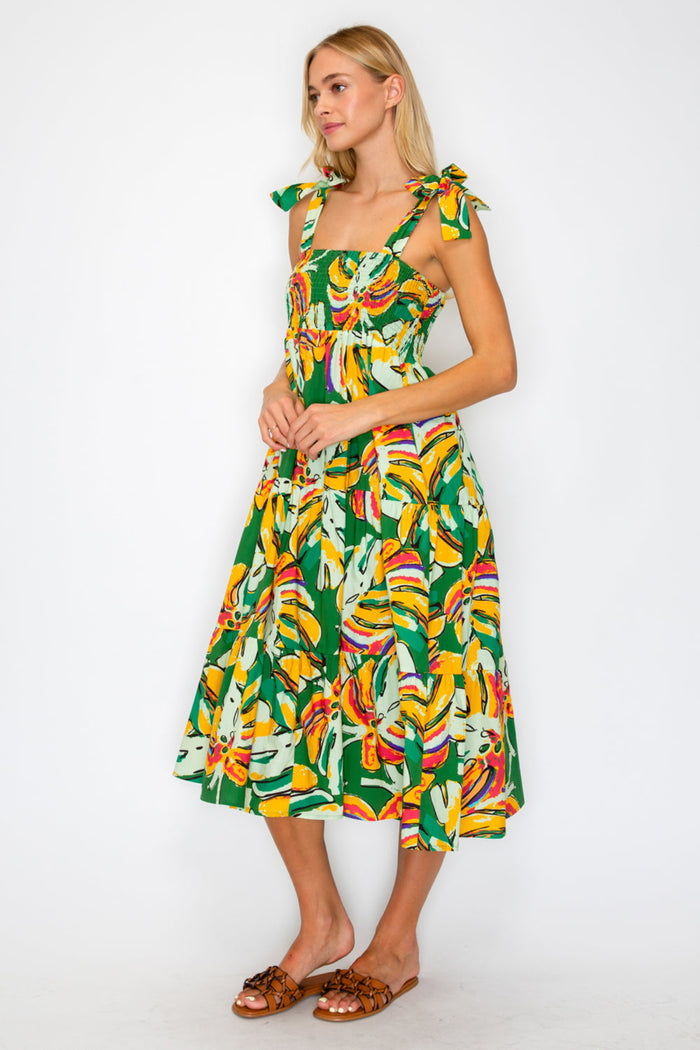 Woman wearing a colorful dress with a leaf pattern on a white background