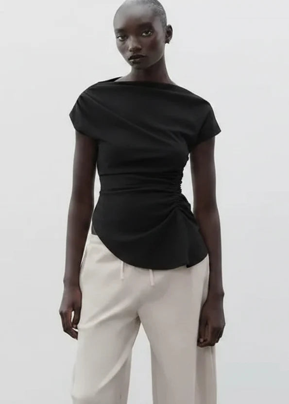 Black short-sleeve boatneck top with ruched side detail and curved hem.