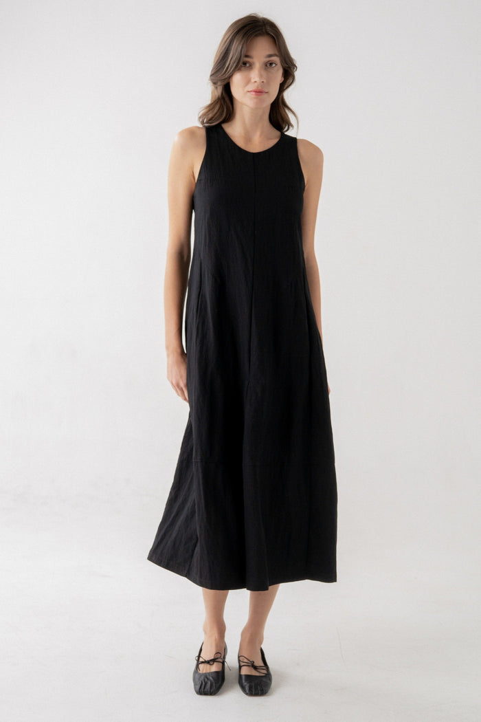 Black sleeveless midi dress with crew neckline and A-line silhouette on model.