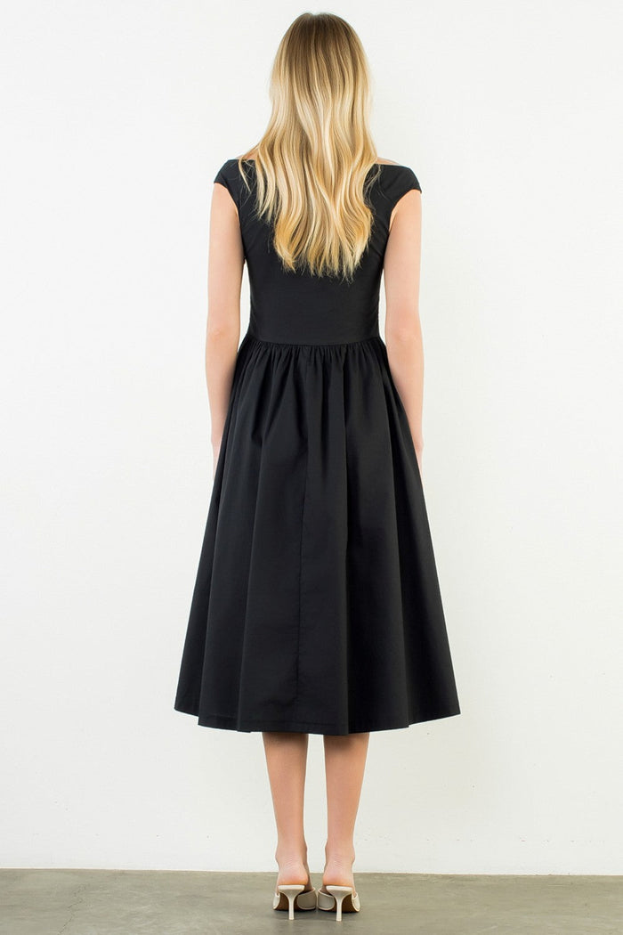 Woman wearing a black dress against a white background