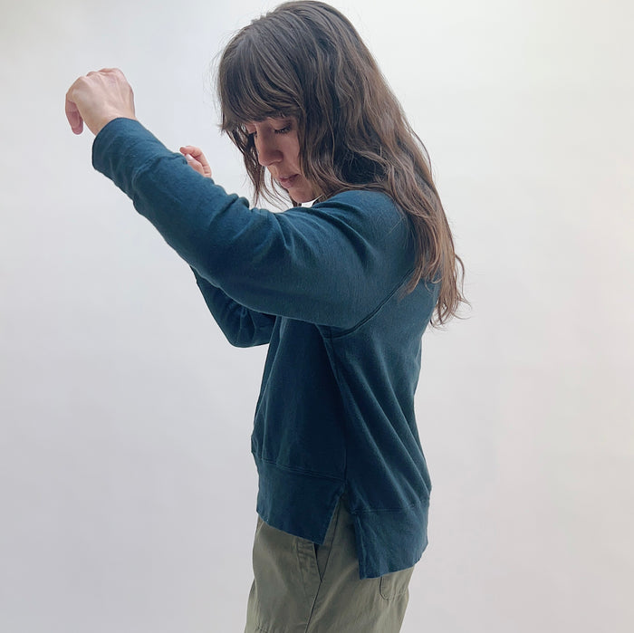 Raglan Sweatshirt in Ink — side view showing relaxed fit, curved hem with side slit, and raglan sleeve construction