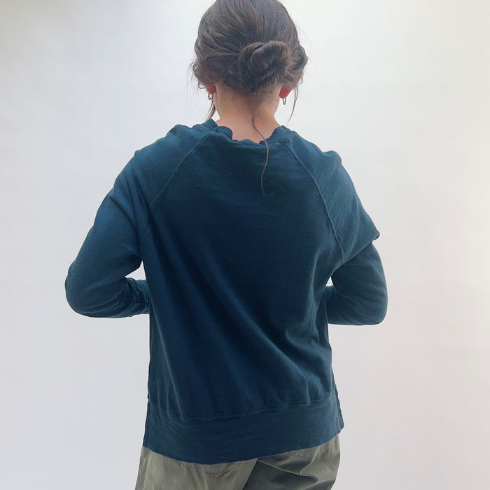 Raglan Sweatshirt in Ink — back view showing raglan seam detail and ribbed hem, styled with olive trousers
