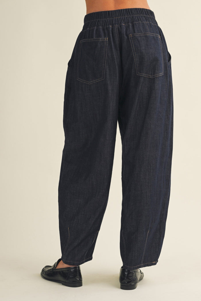 Dark blue denim pants on a beige background