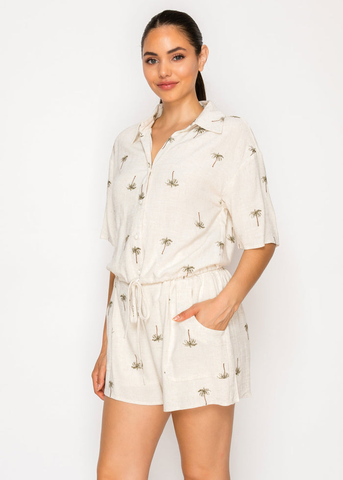 Cream pull-on shorts with palm tree print, drawstring waist, and front pockets.