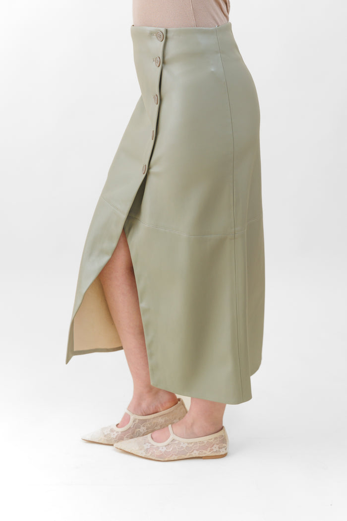 Sage green faux leather midi skirt with button-front closure and side slit, worn with pink ribbed top.