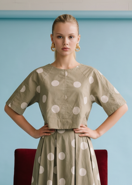 Beige cotton top with white polka dots, short sleeves, and button front closure.
