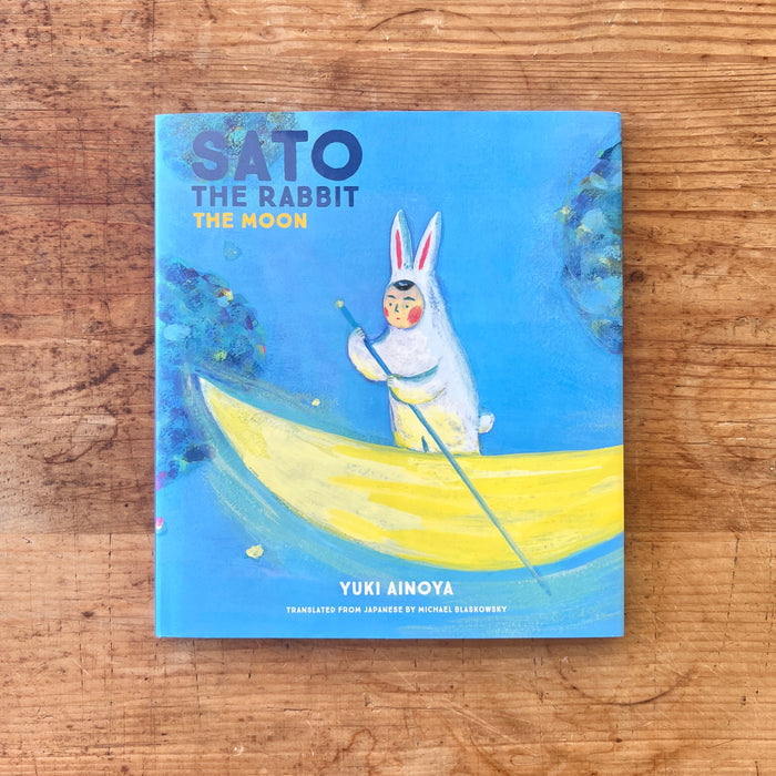 Book titled 'Sato the Rabbit and the Moon' by Yuki Ainoya on a wooden surface