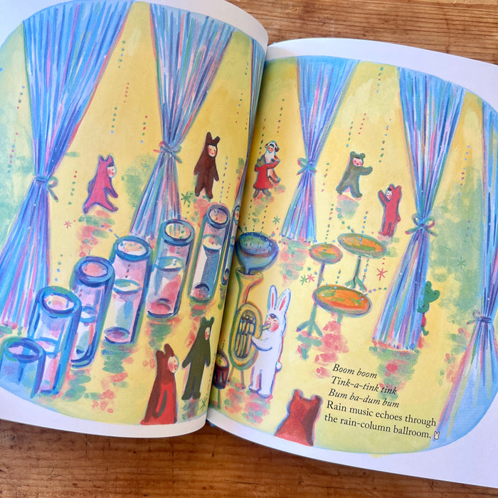 Open book with colorful illustrations of animals and musical instruments on a yellow background.