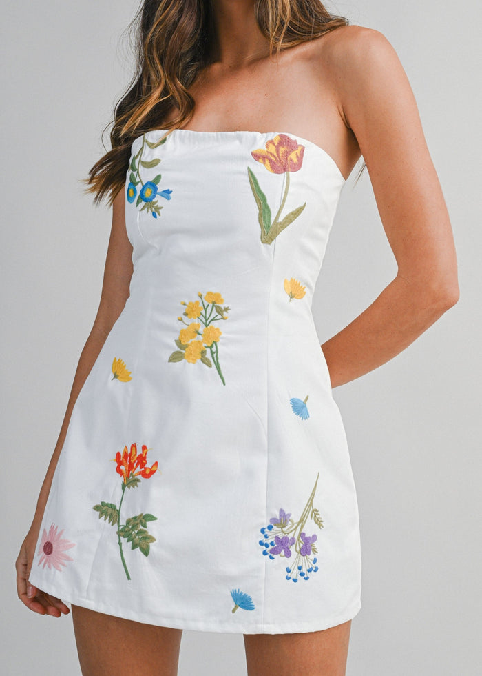 White strapless mini dress with multicolored embroidered floral motifs throughout.