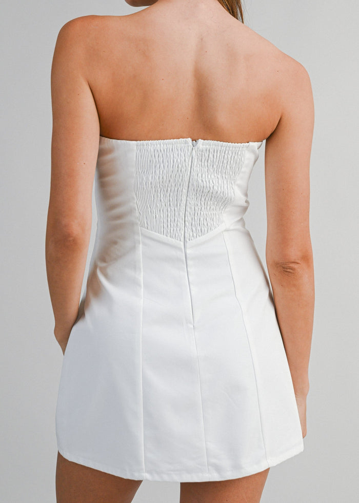 White strapless mini dress with ruched bodice and A-line skirt, shown from back view.