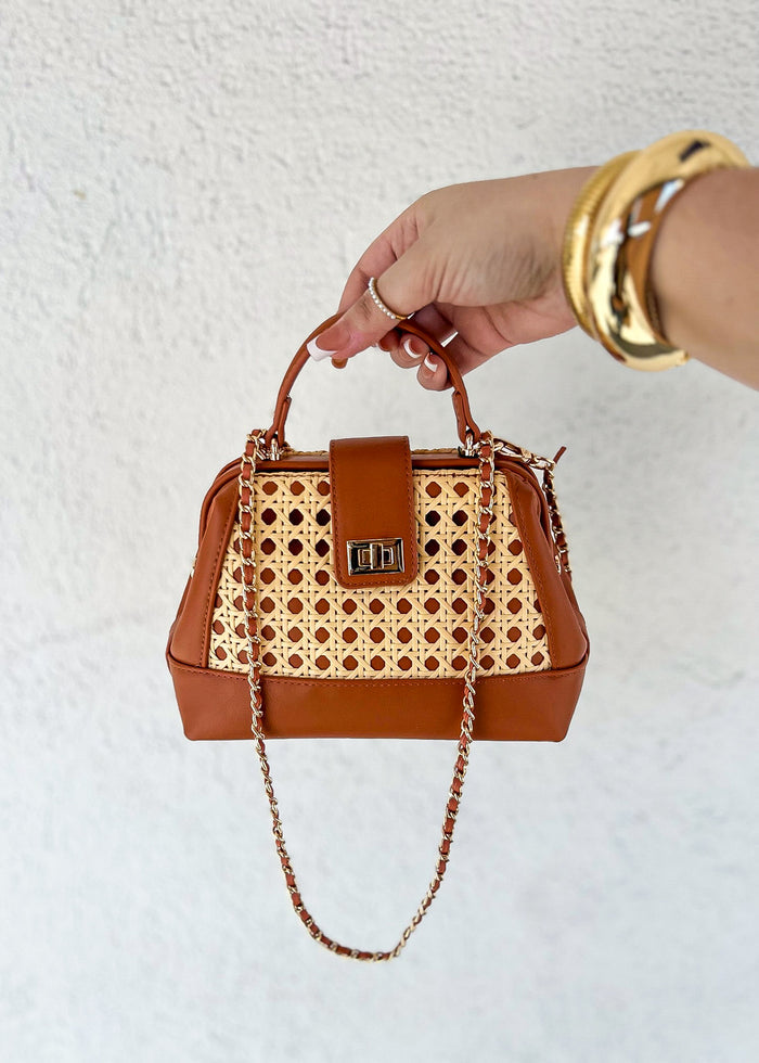 Cognac leather handbag with woven lattice panel, dual handles, chain strap, and gold-tone hardware.