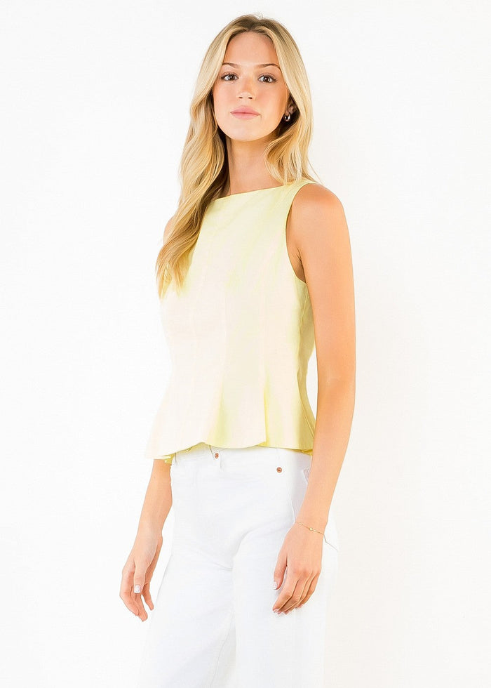 Pale yellow sleeveless peplum top with crew neckline worn with white pants.