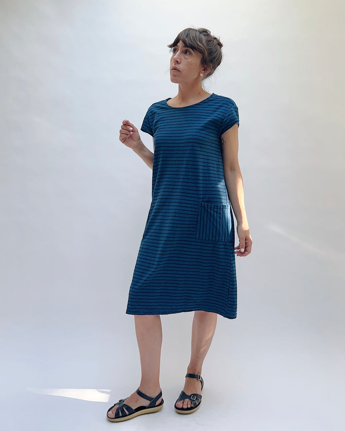 Woman wearing a blue striped dress against a white background