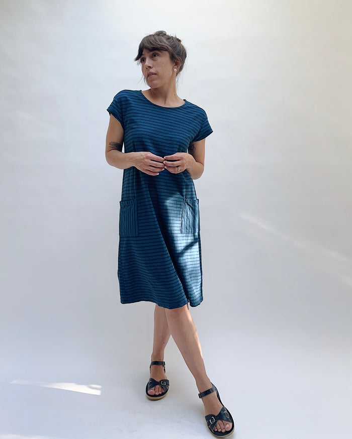 Woman wearing a blue dress against a white background