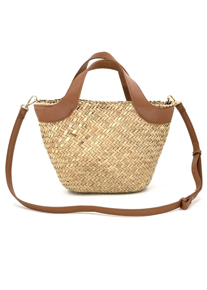 Woven straw tote bag with tan leather handles and removable shoulder strap.