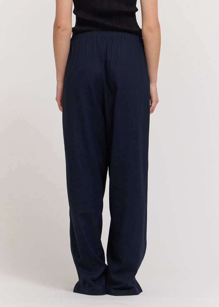 Navy blue pants worn by a person on a white background